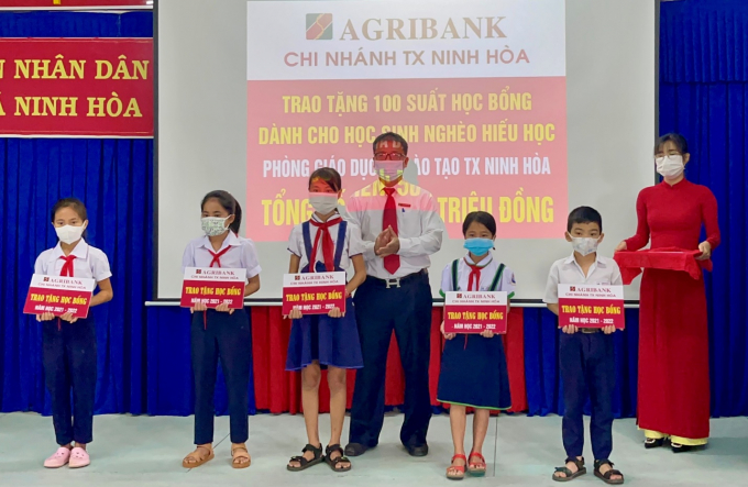 Đại diện Agribank Chi nhánh TX Ninh Hòa trao tặng học bổng cho học sinh. Ảnh: H.Q.