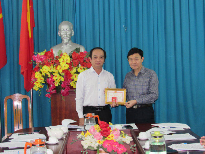 Ông Nguyễn Văn Tỉnh (phải) nhận huy hiệu 
