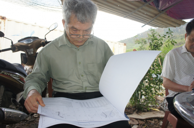 PGS.TS Phạm Hữu Sy đang xem lại bản vẽ thi công đường hầm hồ Sông Chò 1. Ảnh: Ngàn Phố.
