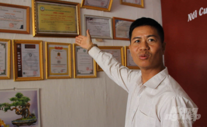 Le Van Vuong with dozens of certificates granted for his company's organic coffee. Photo: Quang Yen.