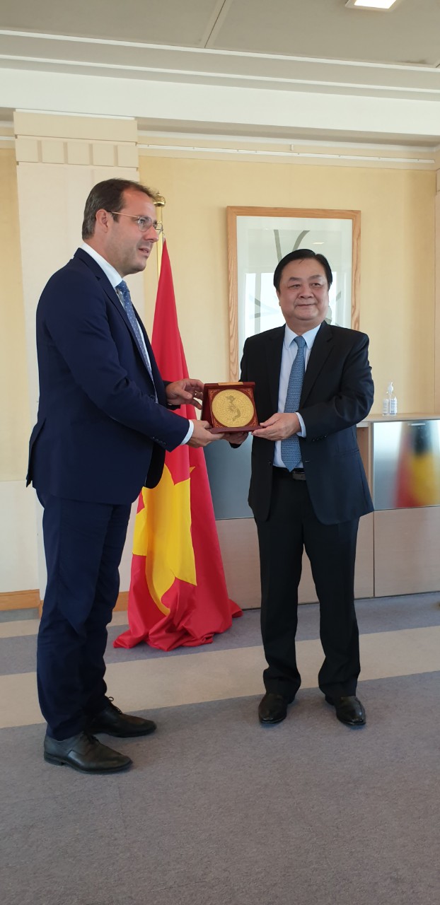 Minister of Agriculture and Rural Development Le Minh Hoan presents a gift to Belgium's Minister of the Middle Class, SMEs, and Self-Employed, David Clarinval. The gift represents Dong Son kettledrum and a map of Vietnam. 
