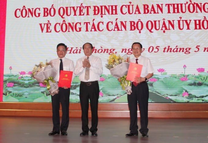 Lãnh đạo Thành ủy Hải Phòng trao Quyết định và tặng hoa cho ông Đoàn Văn Chương - Bí thư Quận ủy Hồng Bàng (về nghỉ hưu) và ông Trần Quang Tuấn (trái) - tân Bí thư Quận ủy Hồng Bàng. Ảnh: HP.