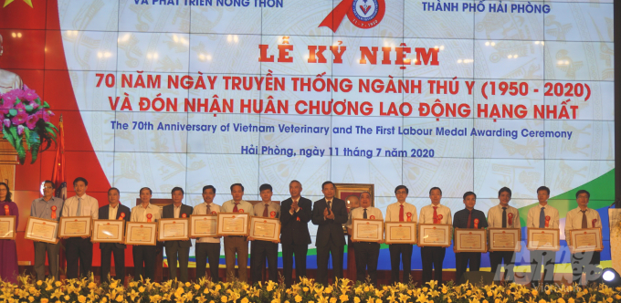 Bộ trưởng Nguyễn Xuân Cường và Thứ trưởng Phùng Đức Tiến trao tặng Bằng khen của Bộ NN-PTNT cho các đơn vị, cá nhân xuất sắc của ngành Thú y. Ảnh: Đinh Mười.