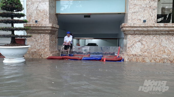 Bảo vệ 1 tòa nhà trên đường Trần Hưng Đạo dùng mọi cách để ngăn nước tràn vào tầng hầm.