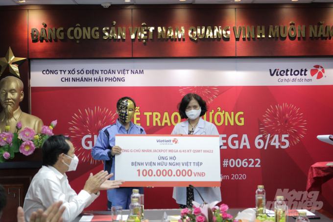 Đại diện Bệnh viện Hữu nghị Việt Tiệp nhận tiền ủng hộ phòng chống dịch Covid-19 từ anh G sáng nay. Ảnh: NNVN.