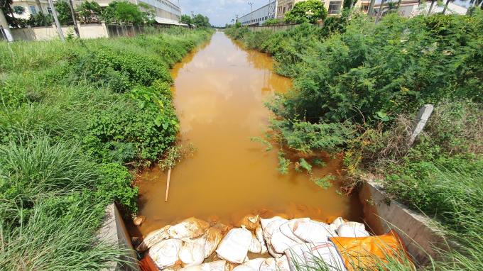 Đoạn kênh có màu bất thường đã bị ngăn lại để tránh lan ra nguồn nước. Ảnh: Đinh Mười.