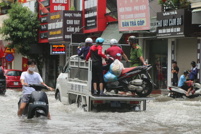 Nhiều xe chết máy hoặc không di chuyển được, lực lượng chức năng phải dùng xe chuyên dụng hỗ trợ người dân di chuyển qua những đoạn nước ngập sâu.