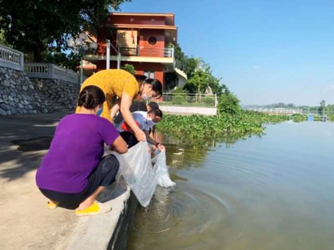 Lãnh đạo Sở NN-PTNT Hải Phòng và người dân thả con giống tái tạo nguồn lợi thủy sản tại xã Kênh Giang, huyện Thủy Nguyên.