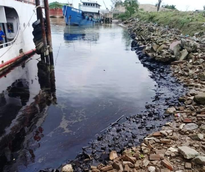 Vệt dầu đen đặc bám lên thành đê ven sông Lam. Ảnh: Nguyễn Công.