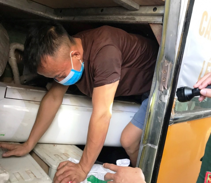 3 công dân trốn trong hầm xe khách để tránh kiểm tra y tế và cách ly tập trung. Ảnh: Minh Toàn.
