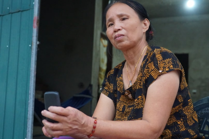 Bà Hoan liên tục nhìn vào màn hình điện thoại chờ cuộc điện thoại thứ 2 của con trai từ khu vực xảy ra vụ sạt lở đất ở thủy điện Rào Trăng 3. Ảnh: Gia Hưng. 