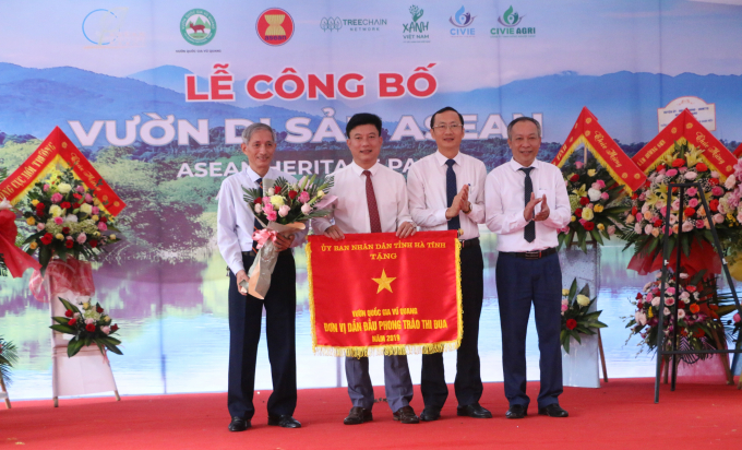 Ông Đặng Ngọc Sơn (thứ 2 bên phải) trao tặng danh hiệu Cờ thi đua cấp tỉnh cho tập thể Vườn. Ảnh: T.Nga.