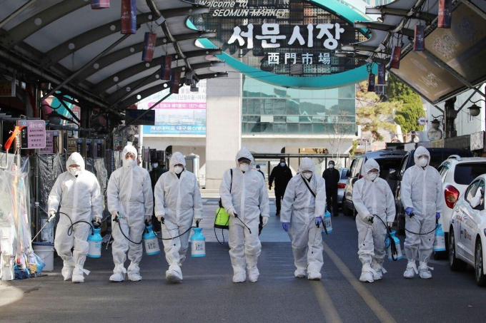 Công nhân phun thuốc khử trùng để đề phòng Covid-19 tại một khu chợ địa phương ở Daegu (Hàn Quốc). Ảnh: Im Hwa-young/Yonhap.