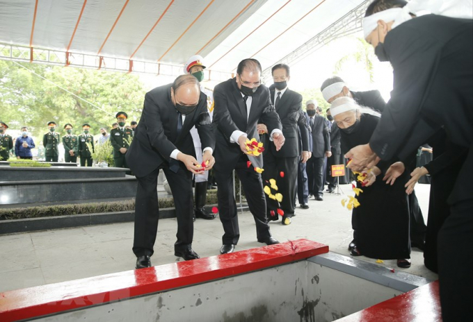 Thủ tướng Nguyễn Xuân Phúc và các vị lãnh đạo Đảng, Nhà nước thực hiện nghi thức thả hoa xuống nơi an táng nguyên Tổng Bí thư Lê Khả Phiêu. Ảnh: TTXVN.