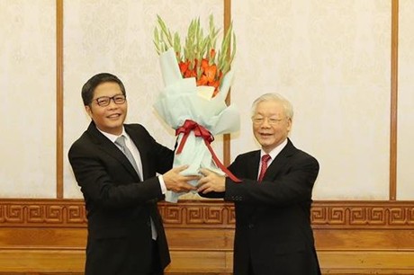 Ông Trần Tuấn Anh nhận hoa chúc mừng từ Tổng Bí thư, Chủ tịch nước Nguyễn Phú Trọng. Ảnh: CP.