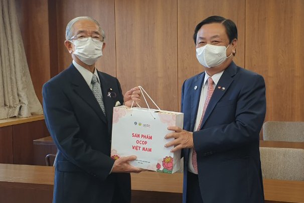 Bộ trưởng Lê Minh Hoan (bên phải) tặng quà OCOP cho Bộ trưởng Bộ Nông Lâm Ngư nghiệp Nhật Bản - Kaneko Genjiro nhân chuyên thăm Nhật Bản ngày 24/11/2021. Ảnh: Anh Tuấn.