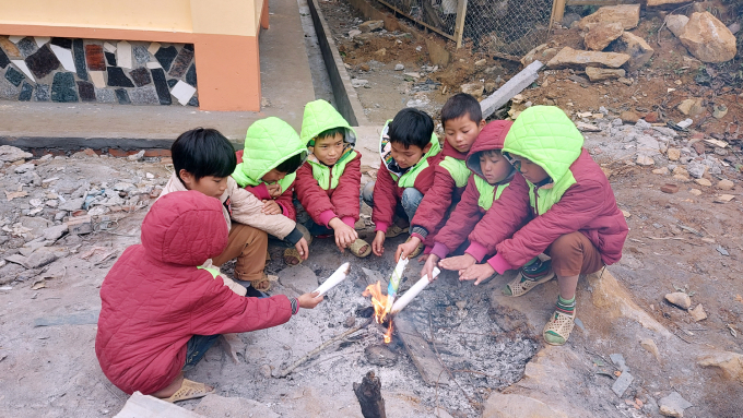 Giờ ra chơi, các em học sinh quây quanh đống lửa sưởi ấm. Nhiều em làm bùi nhùi giấy cầm tay cho khỏi cóng.