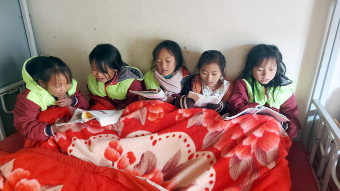 Học sinh tiểu học vùng cao Si Ma Cai đắp chăn ấm ôn bài trong phòng bán trú ngày giá rét.
