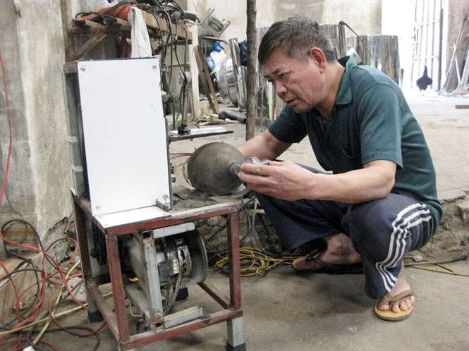 Ông Nguyễn Hữu Mùi chỉnh sửa máy hỗ trợ thở cho người bệnh