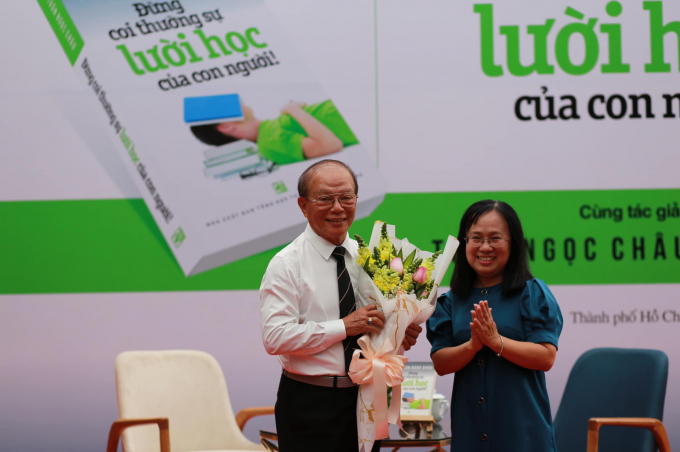 Nhà báo Trần Ngọc Châu nhận hoa chúc mừng từ Giám đốc Nhà xuất bản Tổng hợp TPHCM.