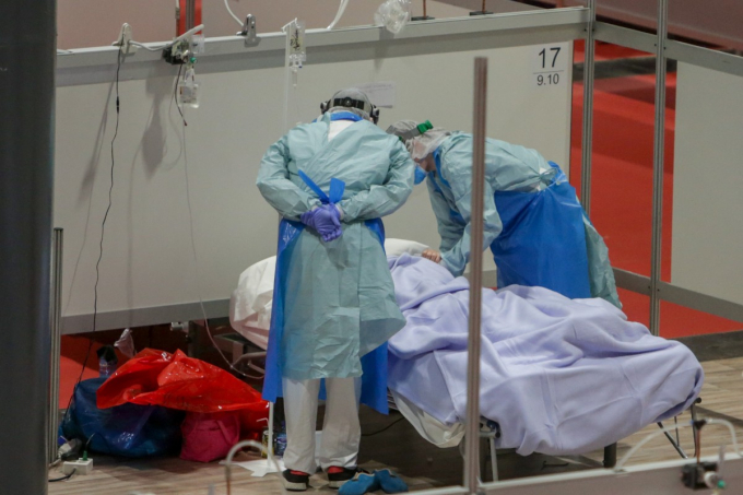 Nhân viên y tế chăm sóc bệnh nhân Covid-19 ở bệnh viện dã chiến được thiết lập tại điểm tổ chức sự kiện IFema ở Madrid. Ảnh: DPA.