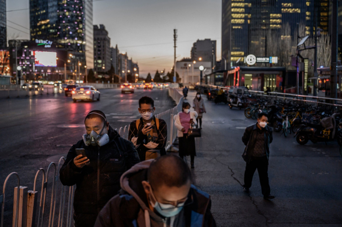 Công dân Trung Quốc đeo khẩu trang khi chờ xe buýt ở Bắc Kinh, 20/3. Ảnh: Getty Images