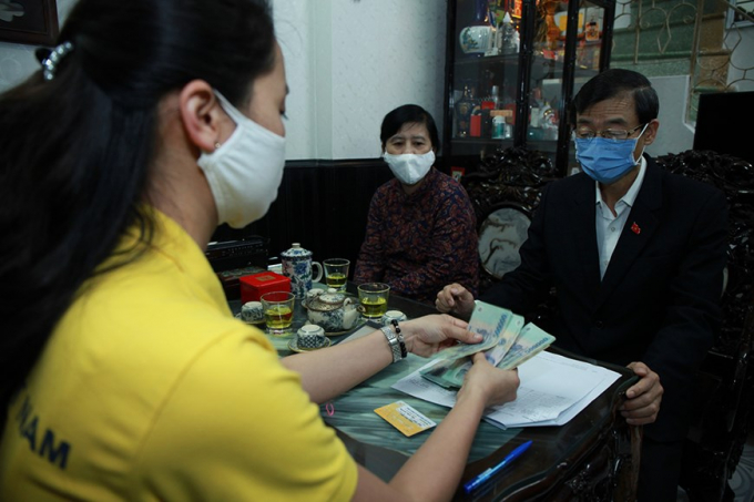 Từ ngày 16/4, người được hưởng lương hưu và trợ cấp bảo hiểm xã hội sẽ được nhận tiền tại nhà. Nguồn: Vietnam+.