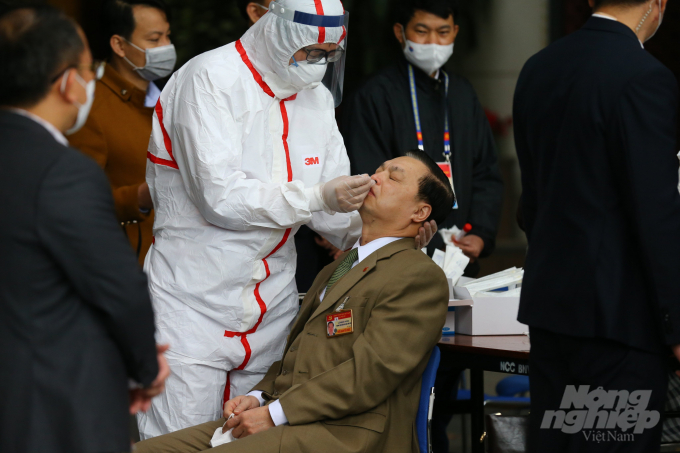 Nhân viên y tế lấy dịch ở mũi và họng để xét nghiệm Covid-19 cho ông Lê Mạnh Hùng - Phó Trưởng ban Tuyên giáo Trung ương.