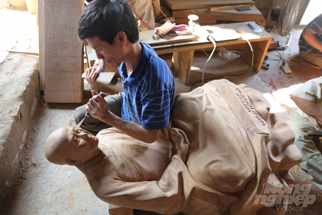 Nghệ nhân Nguyễn Đức Duy đang khắc họa những đường nét trên gương mặt tượng Phật. Ảnh: Minh Phúc.