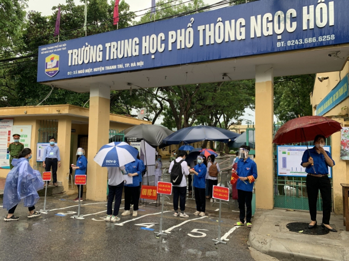 Đoàn viên thanh niên huyện Thanh Trì đo thân nhiệt, hỗ trợ thí sinh vào phòng thi sáng 13/6.