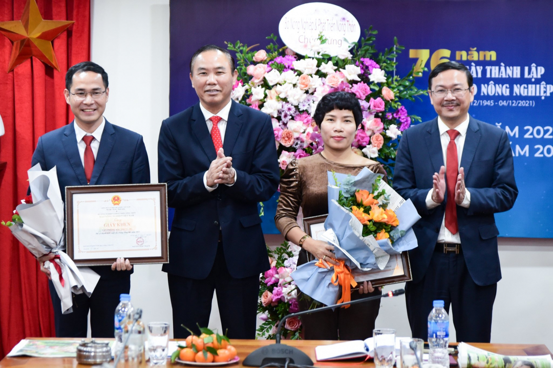 Thứ trưởng Bộ NN-PTNT Phùng Đức Tiến cùng Tổng Biên tập Báo Nông nghiệp Việt Nam Nguyễn Ngọc Thạch tặng hoa, giấy khen cho tập thể có thành tích xuất sắc trong công tác năm 2021. Ảnh: Tùng Đinh.
