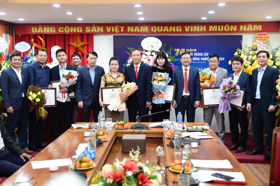 Thứ trưởng Bộ NN-PTNT Phùng Đức Tiến cùng Tổng Biên tập Báo Nông nghiệp Việt Nam Nguyễn Ngọc Thạch tặng hoa, giấy khen cho các cá nhân có thành tích xuất sắc trong công tác năm 2021. Ảnh: Tùng Đinh.