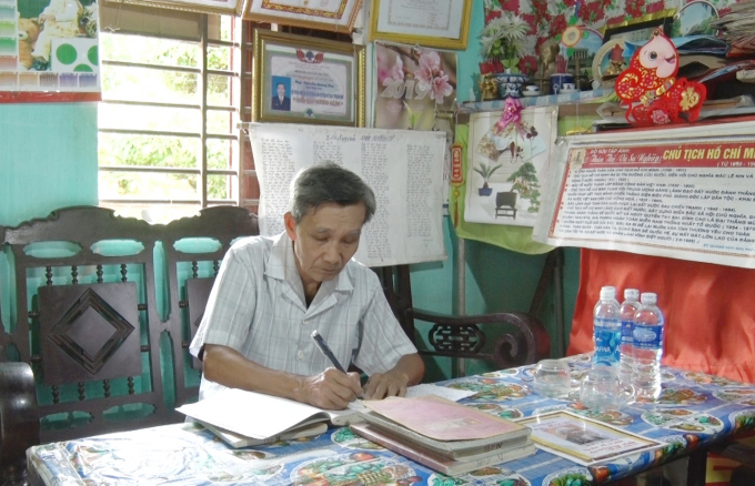 Ông Nguyễn Quang Huy vẫn miệt mài chép bài báo về Bác Hồ vào cuốn sổ trong bộ sưu tập của mình. Ảnh: T.Phùng.
