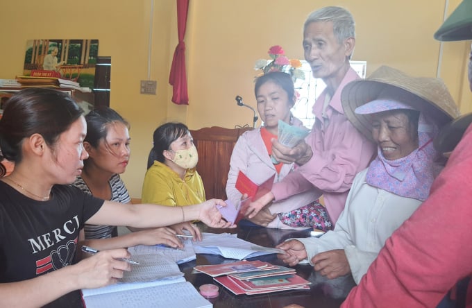 Người dân thôn Phú Lộc (xã Gia Ninh) nhận tiền hỗ trợ. Ảnh: T. Phùng.