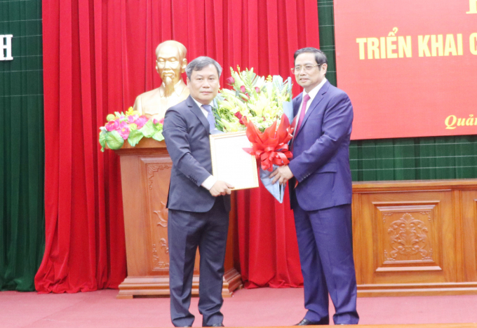 Ông Phạm Minh Chính trao quyết định, tặng hoa cho tân Bí thư Tỉnh ủy Quảng Bình Vũ Đại Thắng (bên trái). Ảnh: N.Tâm.