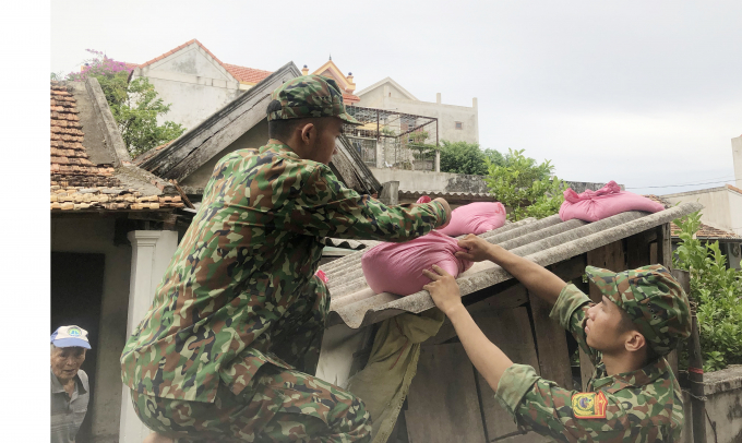 Bộ đội giúp người dân thuộc hộ nghèo ở huyện Bố Trạch gia cố mái nhà chống bão. Ảnh: Đ.Trí