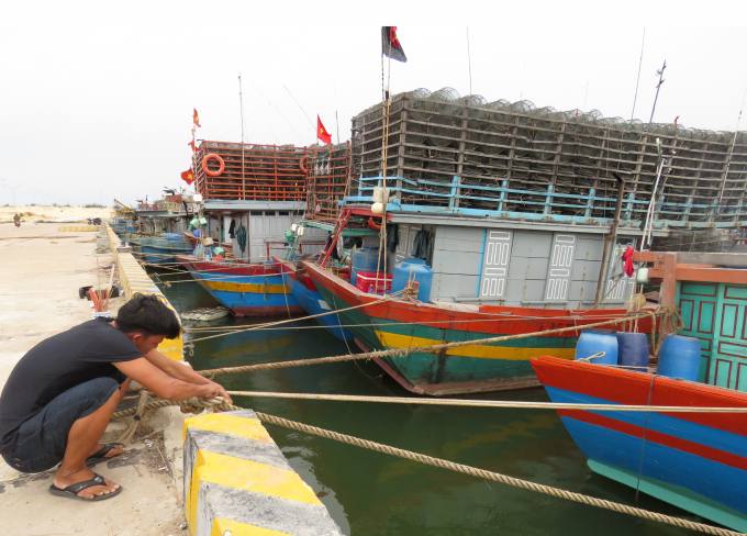 Ngư dân buộc, neo tàu tại khu neo đậu Cửa Thôn. Ảnh: H.Châu.