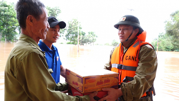 Đại tá Bùi Quang Thanh, Phó Giám đốc Công an Quảng BÌnh trao quà cho người dân vùng ngập lụt Bố Trạch. Ảnh: Q. Văn.