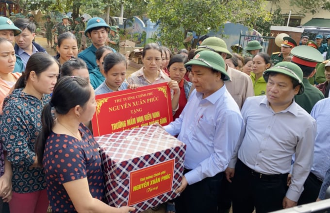 Thủ tướng Nguyễn Xuân Phúc thăm hỏi, tặng quà cho các hộ gia đình chính sách tại thôn Đồng Tư, xã Hiền Ninh. Ảnh: T.Phùng