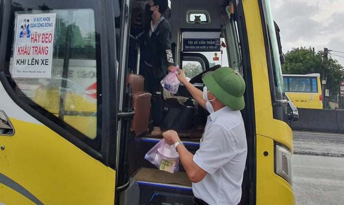 Trao cơm hộp cho những người được ô tô đón đưa qua địa phận tỉnh Quảng Bình. Ảnh: L. Hương