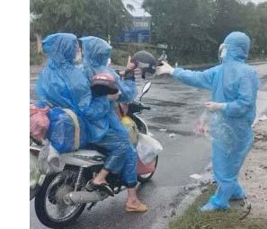 Nhóm thiện nguyện trao tặng mũ bảo hiểm cho những người đi đường còn thiếu hoặc đã hư hỏng. Ảnh: L.Hương