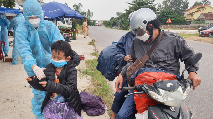 Chị Trần Quỳnh Trang mang áo ấm cho một cháu bé. Ảnh: N.T