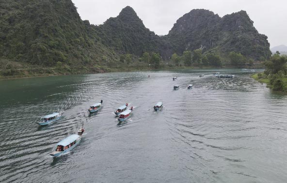 Du khách đi thuyền trên sông Son tham quan động Phong Nha. Ảnh: V.Q