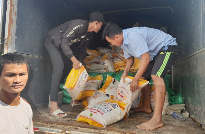 Thanh niên làng Thạch Bắc tự nguyện bốc, vận chuyển gạo đi cứu trợ cho bà con vùng bị mưa lũ tàn phá. Ảnh: N.Tâm