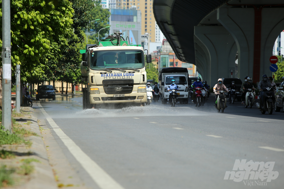 Đường Trường Chinh được xe phun rửa làm dịu mát giúp người dân đi lại bớt nóng bức hơn.