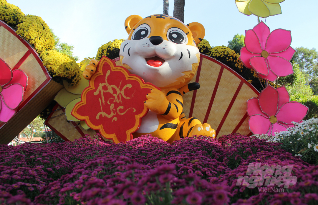 Một chú hổ ngộ nghĩnh được trang trí đứng cạnh hàng nghìn bông hoa cúc. 