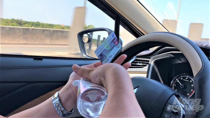 Sau mỗi lần giao dịch tiền, vé khi qua trạm thu phí, các tài xế lại dùng chai nước rửa tay khô xịt tay, thẻ, vé và các vật dụng khác trong xe. Ảnh: MV 