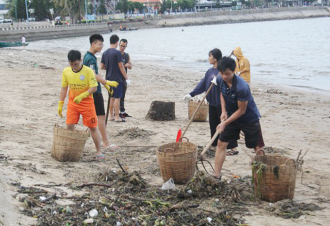 Nhiều công nhân môi trường và các bạn trẻ được huy động đến thu gom rác làm sạch bãi biển. Ảnh: AV.