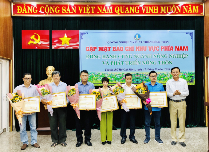 Thứ trưởng Thường trực Hà Công Tuấn trao Bằng khen của Bộ trưởng Bộ NN-PTNT cho nhà báo Trần Thanh Sơn (người đứng thứ 3 từ bìa trái vào), cùng các nhà báo trong CLB phóng viên Kinh tế Nông nghiệp TP.HCM. Ảnh: ĐC.  