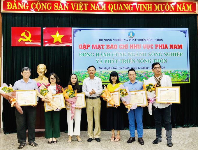 Thứ trưởng Thường trực Hà Công Tuấn trao Bằng khen của Bộ trưởng Bộ NN-PTNT cho nhà báo Nguyễn Minh Sáng (người đứng thứ 2 từ bìa phải vào), cùng các nhà báo trong CLB phóng viên Kinh tế Nông nghiệp TP.HCM. Ảnh: ĐC.  